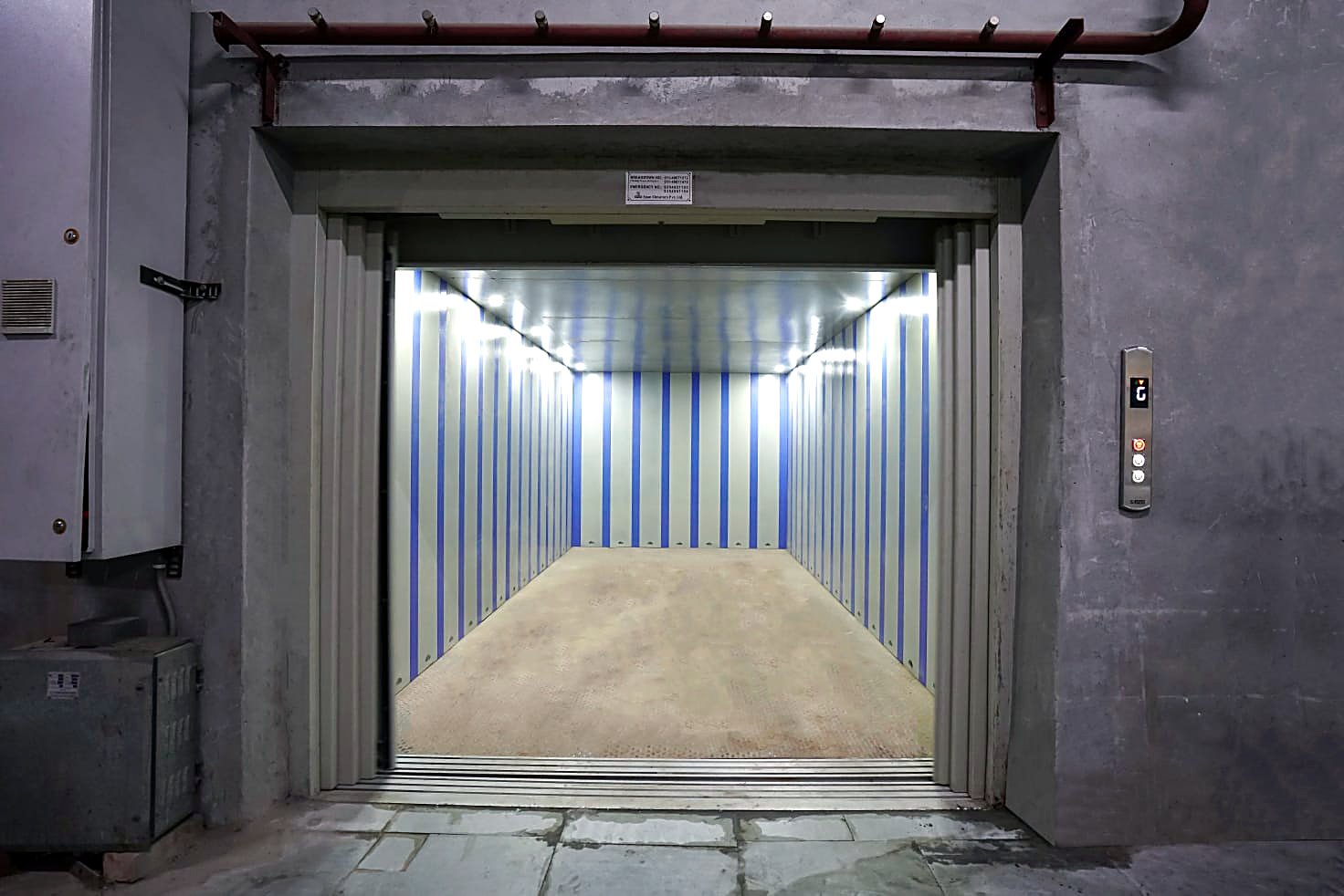 Span car elevator — open steel platform with panelled walls and Span landing controls.