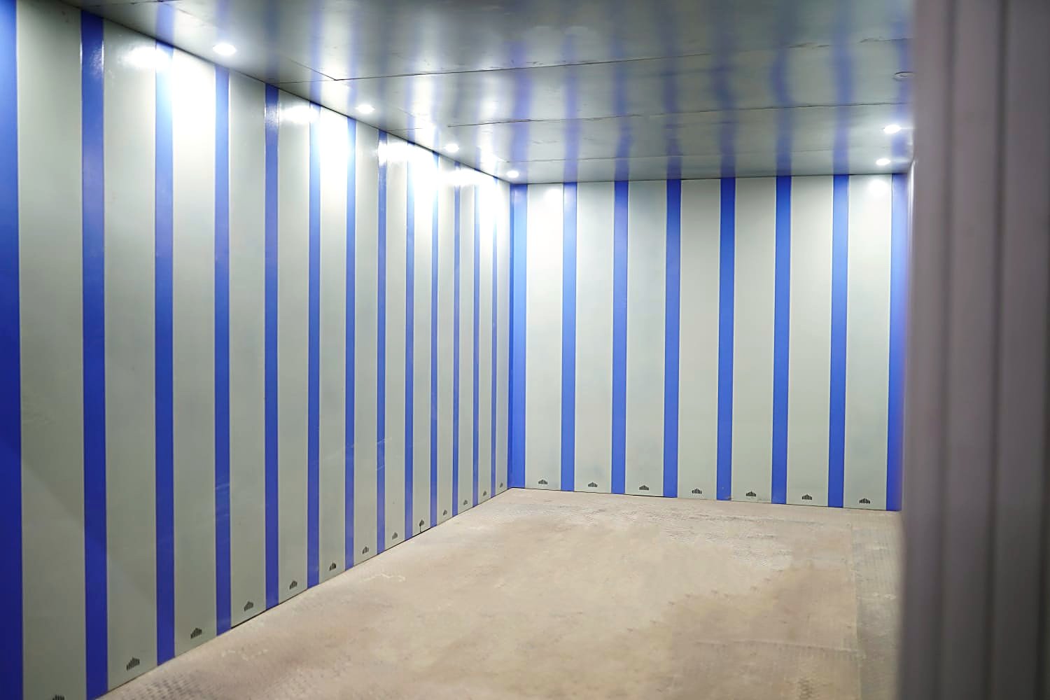 Span car elevator platform interior — chequered-steel deck, panelled walls, recessed LED lighting.