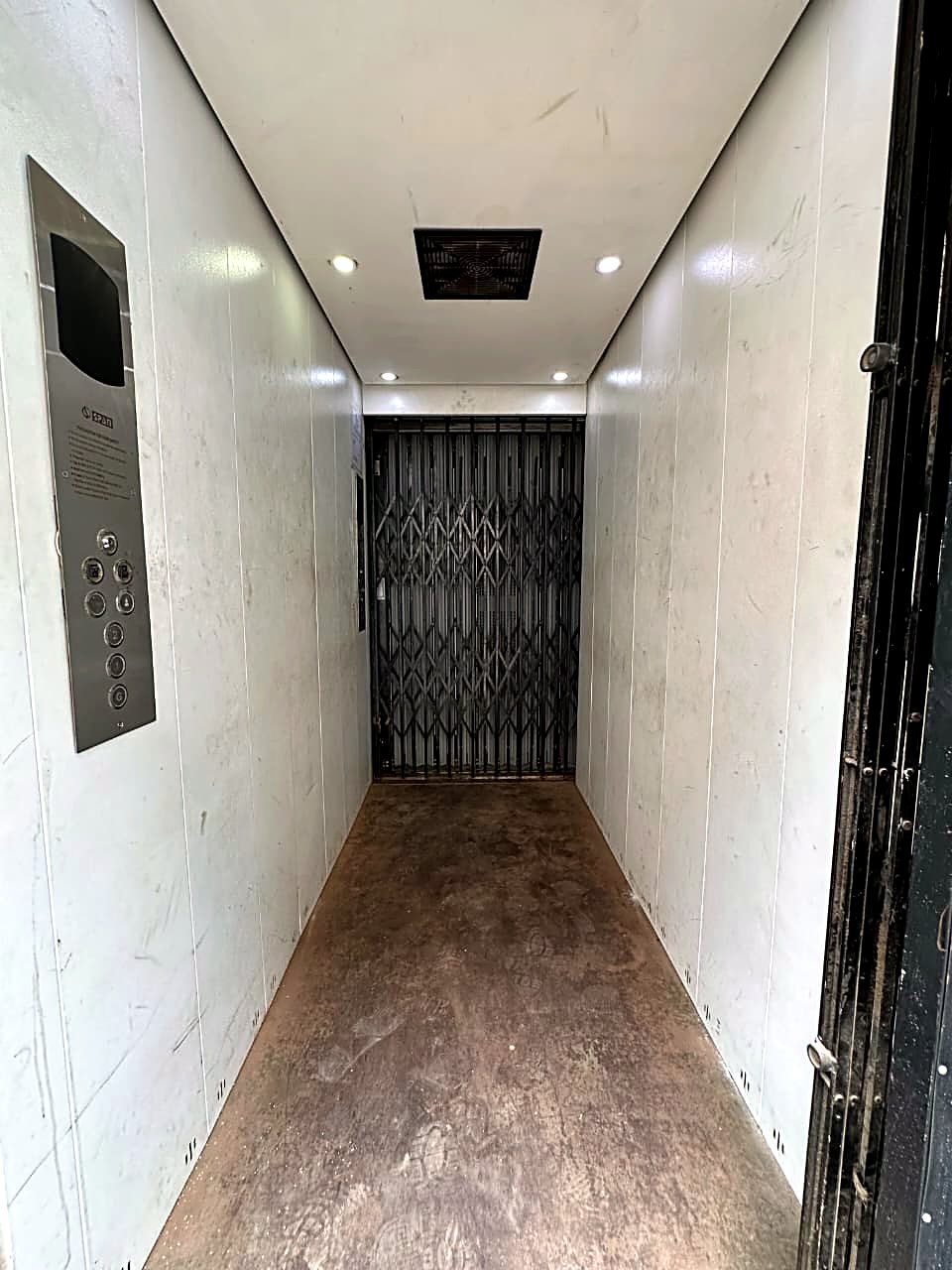 Span Bhāravāha goods-cum-passenger lift — white-panel cabin with a collapsible steel gate and Span control panel.