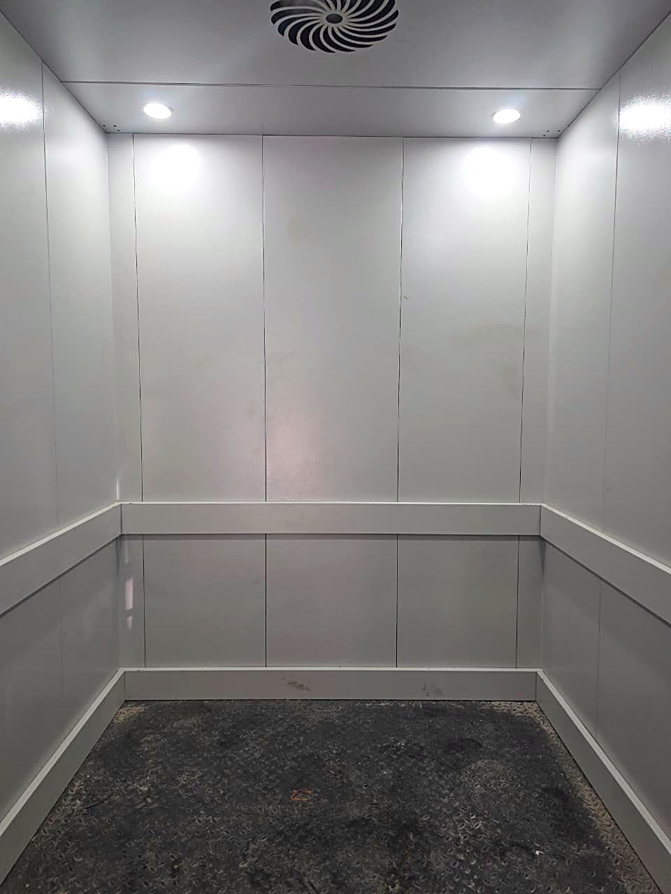 Span Bhāravāha goods-cum-passenger cabin — white laminate panels, chequered-plate floor and ventilated ceiling.