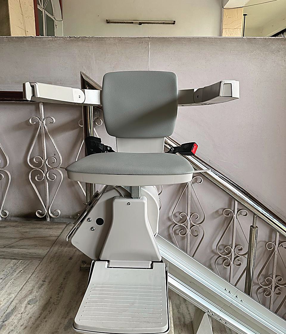 Span-installed curved-rail stairlift on a residential staircase in Delhi.